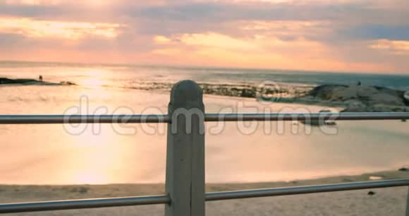 站在沙滩栏杆旁的女人视频的预览图