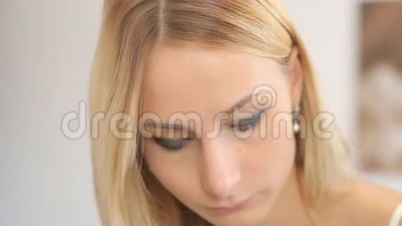 年轻女子在镜子前化妆满脸背景模糊视频的预览图