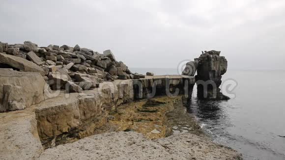 英国波特兰多塞特岛上波特兰比尔灯塔的岩石堆视频的预览图