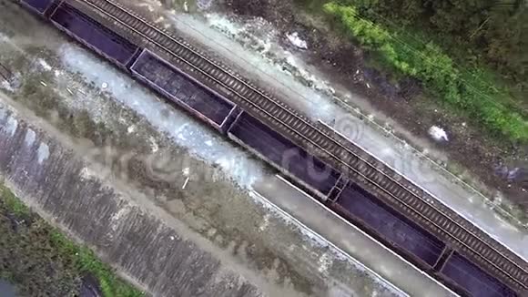 货运列车上的鸟瞰图穿过大桥火车或货运列车从天空进入铁路视野查看视频的预览图