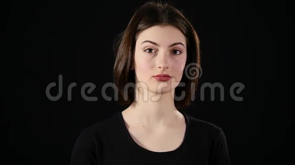 年轻女子在黑色背景下调情视频的预览图