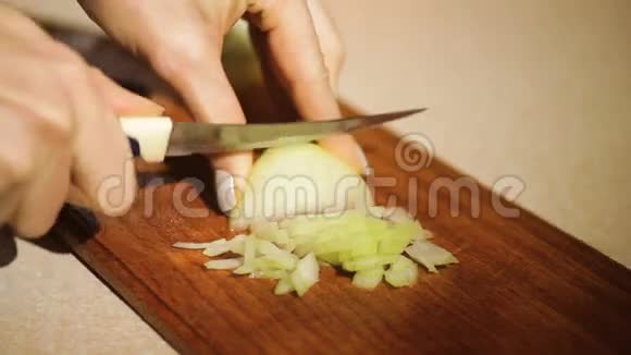 女人在菜刀上切洋葱视频的预览图