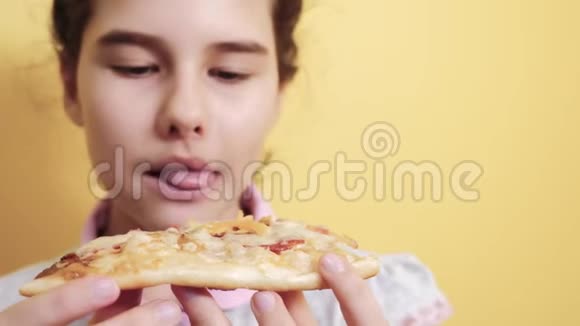 快乐的小女孩吃一片披萨的概念生活方式青少年儿童饥饿吃一片比萨饼慢动作视频的预览图