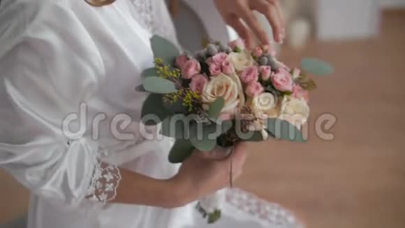 穿着浴袍的美女看着婚礼花束视频的预览图