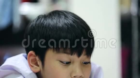 亚洲可爱男孩在家里地板上看书视频的预览图