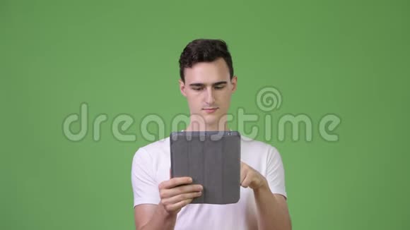 年轻的帅哥用数码平板电脑获取好消息视频的预览图