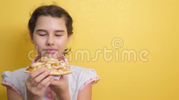 快乐的小女孩吃一片披萨的概念十几岁的孩子饿了吃一片披萨慢生活方式视频的预览图