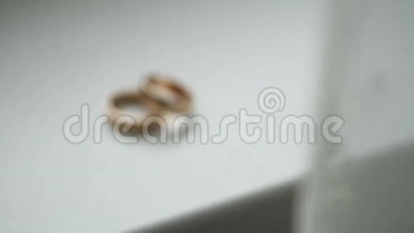 白色桌子上的结婚戒指背景视频的预览图
