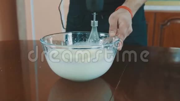 面包师用搅拌器将牛奶倒入玻璃碗中视频的预览图