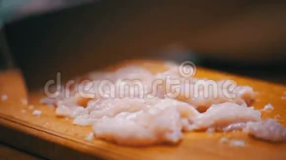 女人的手与刀切肉在木制的切割板在家庭厨房慢动作视频的预览图