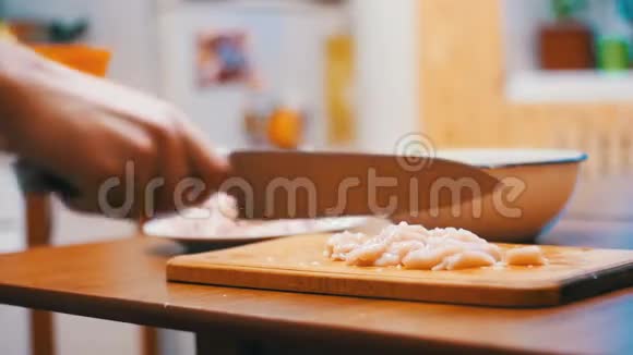 女性手与刀切肉在木制切割板在家庭厨房慢动作视频的预览图