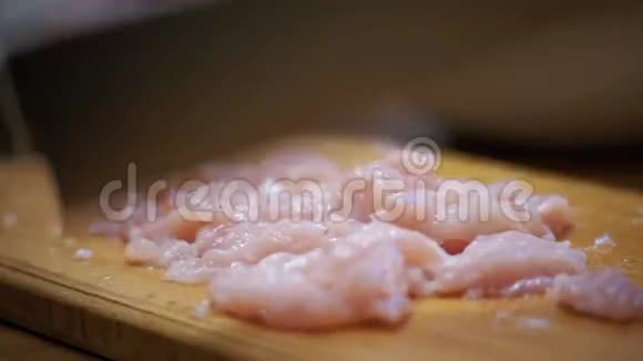 女性手与刀切肉在木制切割板在家庭厨房慢动作视频的预览图