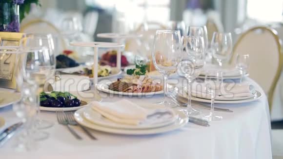 在餐厅的白色桌子上摆放健康食品和白色盘子和用具视频的预览图