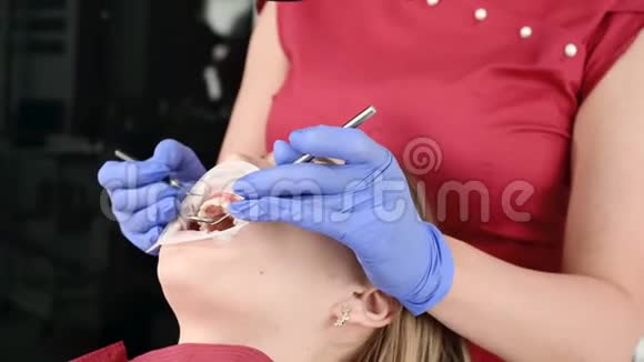 一位女性专业牙医在她的办公室里用雄蕊显微镜检查一位女性病人斯塔姆学家视频的预览图