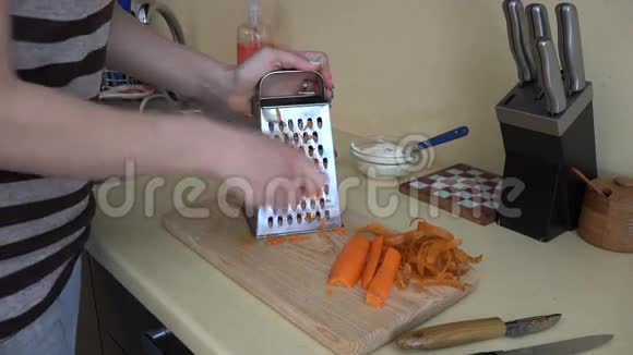 女手篦橙胡萝卜与碎纸机工具在厨房4K视频的预览图