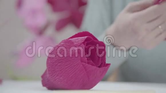 女性手中亮粉色的瓦楞纸特写视频的预览图