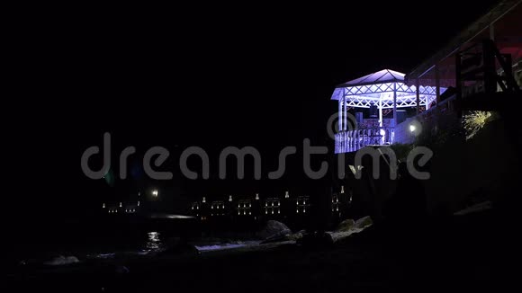 夜晚海滩上的餐厅当月光照亮海浪视频的预览图