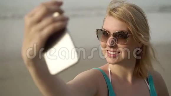 沙滩上年轻的金发女郎自拍视频的预览图