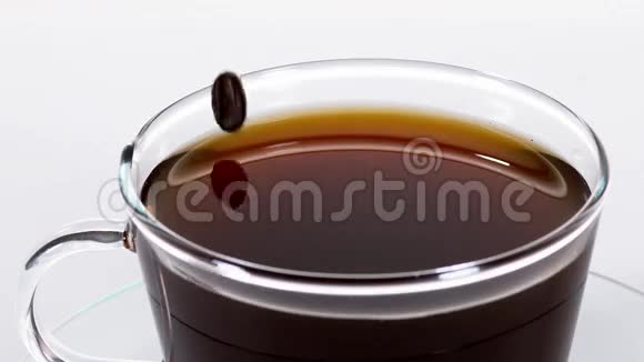 咖啡豆落在白色背景下的杯中视频的预览图