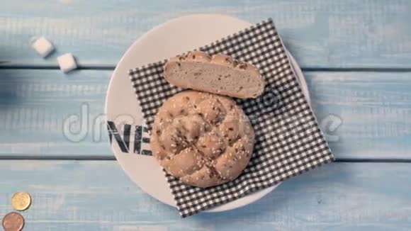 昂贵的面包一杯咖啡和两片糖放在蓝色的木桌上视频的预览图