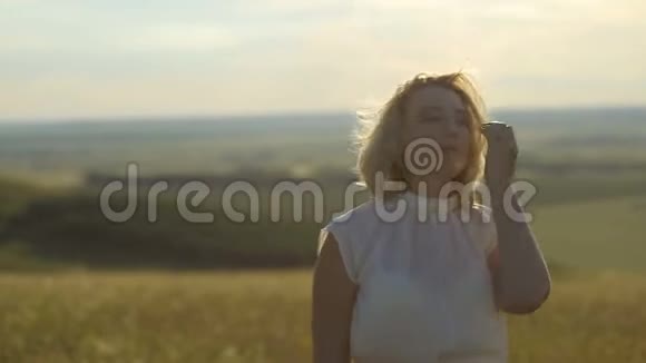 美丽的女人在日落的天空上奔跑在麦田上自由概念户外快乐的女人收获麦田视频的预览图
