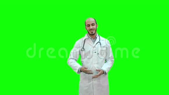 微笑的医生在绿色屏幕上与相机交谈Chroma键视频的预览图