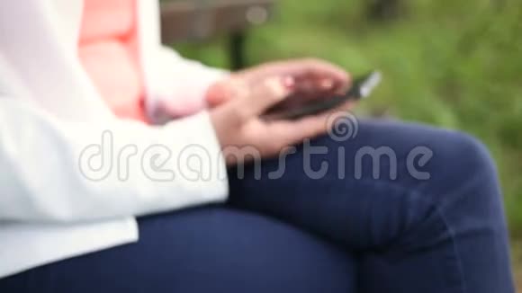 公园里拿着智能手机的年轻女子滑动滑块视频的预览图