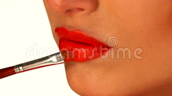 年轻女子用刷子涂红唇膏视频的预览图