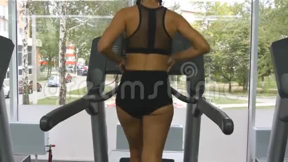 年轻强壮的女人有着完美的健身身材穿着运动服在健身房跑步机上跑步女子有氧运动视频的预览图