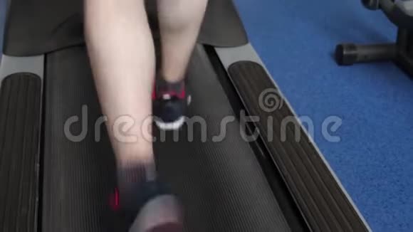 通过走路加强腿部肌肉特写镜头心脏负荷一个人在跑步机上训练在健身房散步健身健身视频的预览图