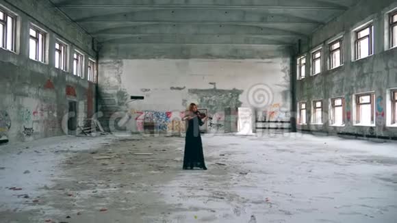 废弃的建筑和一个在里面拉小提琴的女人视频的预览图