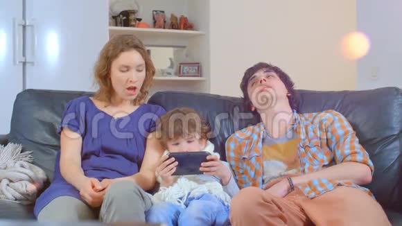 无聊的一家人坐在沙发上视频的预览图
