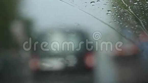 下雨的交通透过挡风玻璃看离焦的交通大雨倾盆雨刷吱吱作响视频的预览图