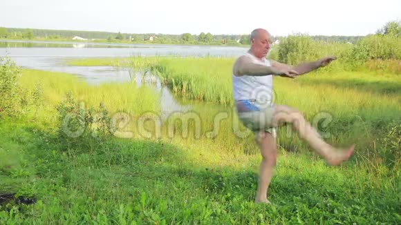一位老人早上在湖边做伸展运动视频的预览图
