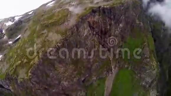 空中跳伞降落在被绿色和雪覆盖的山上峡谷视频的预览图