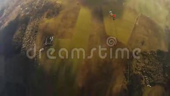 跳伞员在绿色陆地上方的云层中打开降落伞极限运动晴天视频的预览图