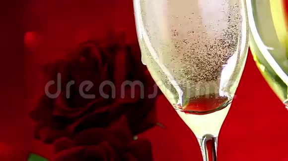 在红树背景爱情和情人节的概念上在红色玫瑰的附近用气泡浇上香槟视频的预览图