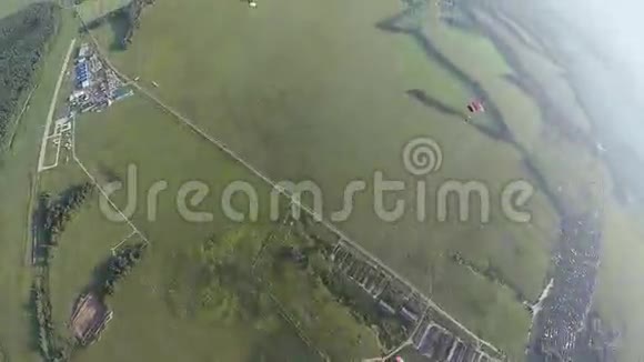 跳伞女孩跳伞在绿色的土地森林上空极限运动阳光明媚视频的预览图