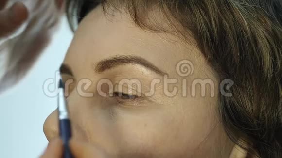 专业化妆师在眼睑上涂眼线的特写画师用眼线来弥补女性视频的预览图