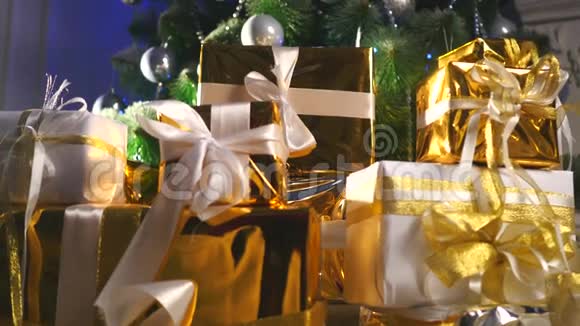 圣诞树下的豪华礼品盒新年家庭装饰品圣诞礼物的金色包装节日冷杉树视频的预览图