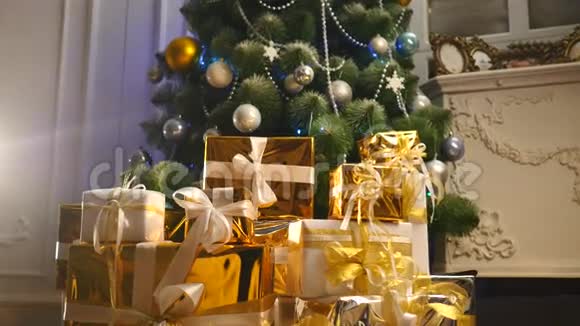 圣诞树下的豪华礼品盒新年家庭装饰品圣诞礼物的金色包装节日冷杉树视频的预览图