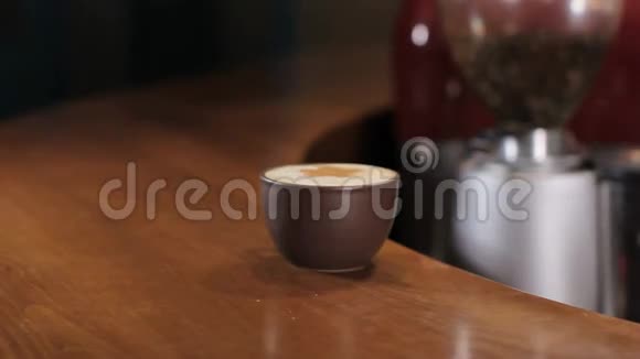 酒保在木条柜台上提供咖啡卡布奇诺女孩把它捡起来视频的预览图