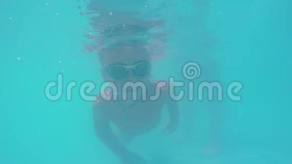 孩子在游泳池的蓝水里潜水视频的预览图