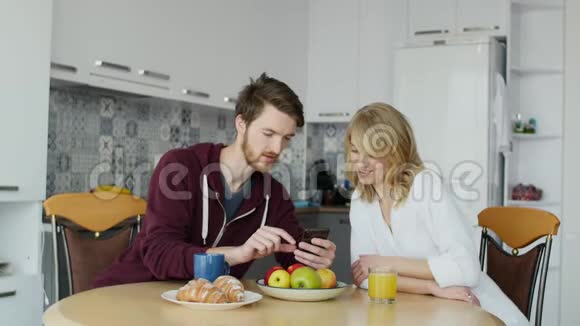很有魅力的一对夫妇在厨房的家里一起吃早餐视频的预览图