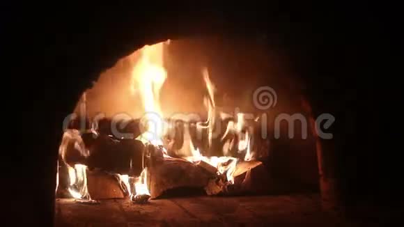 在柴火炉中燃烧的火焰和余烬的特写视频的预览图