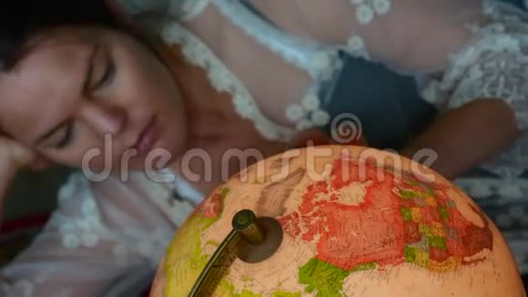 女人在老式地球仪上寻找旅行目的地视频的预览图