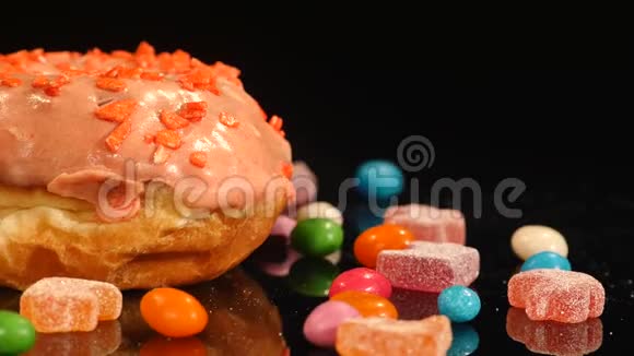 橙色的有趣的惊喜的上釉甜甜圈带条纹的焦糖糖糖果五颜六色的德拉吉葡萄干或花生视频的预览图
