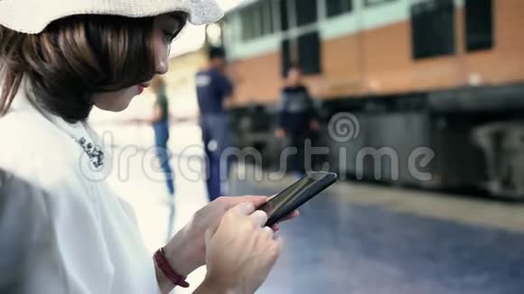 旅行背包客亚洲妇女在曼谷旅游泰国快乐的年轻女性坐在长凳上用智能手机聊天视频的预览图