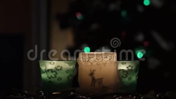 三支美丽的蜡烛在闪烁的圣诞树背景上视频的预览图