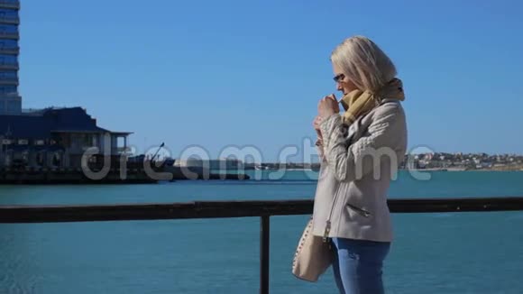 年轻漂亮的女人抽烟背景是大海视频的预览图